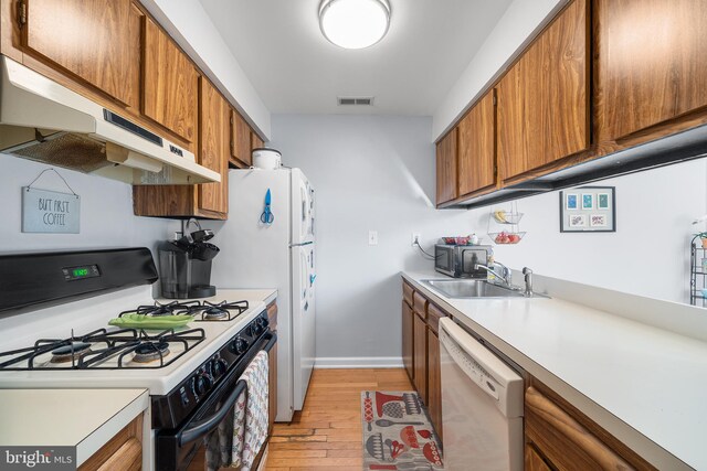 kitchen featuring light hardwood / wood-style floors, sink, and white appliances