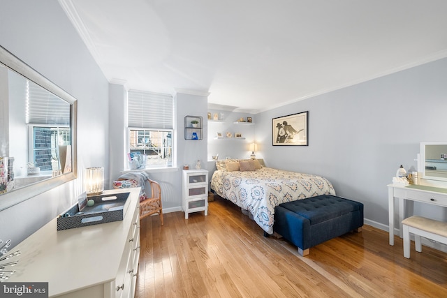 bedroom featuring ornamental molding and light wood-type flooring