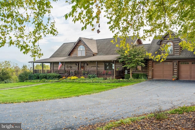 log cabin featuring a front lawn and covered porch