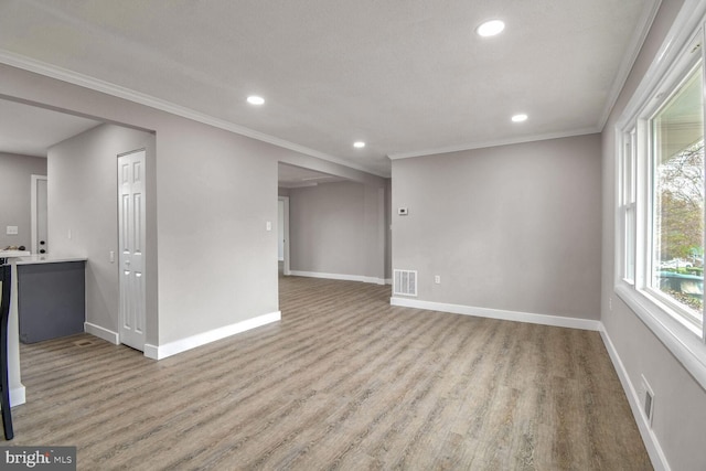 unfurnished living room with light wood-type flooring and ornamental molding