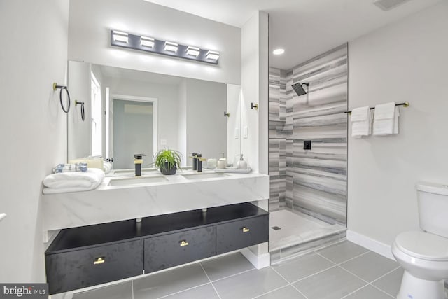 bathroom featuring a tile shower, tile patterned flooring, vanity, and toilet