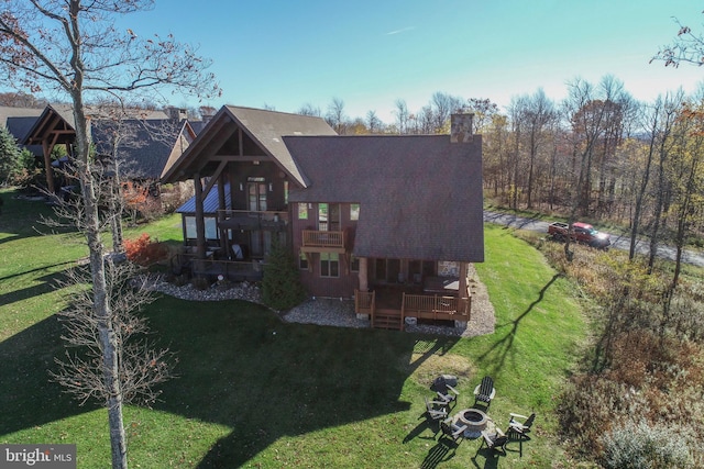 rear view of property with a deck and a lawn