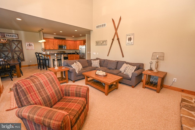 living room featuring a high ceiling and light carpet