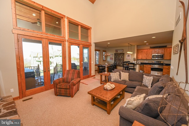 carpeted living room featuring french doors and a high ceiling