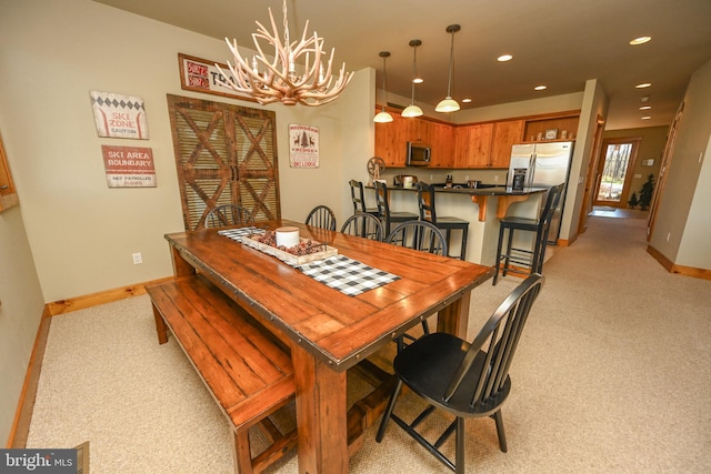 carpeted dining area featuring an inviting chandelier