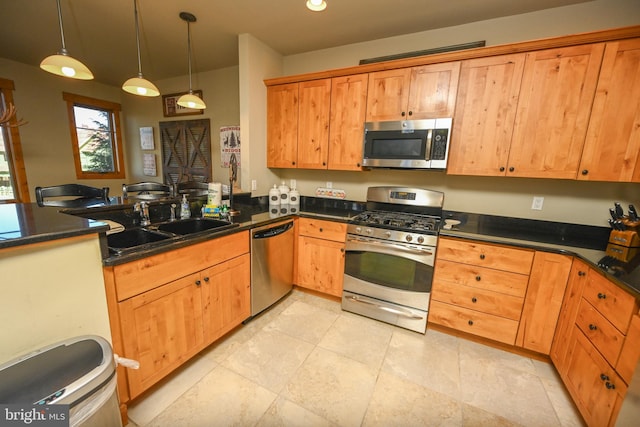 kitchen featuring sink, appliances with stainless steel finishes, kitchen peninsula, and decorative light fixtures