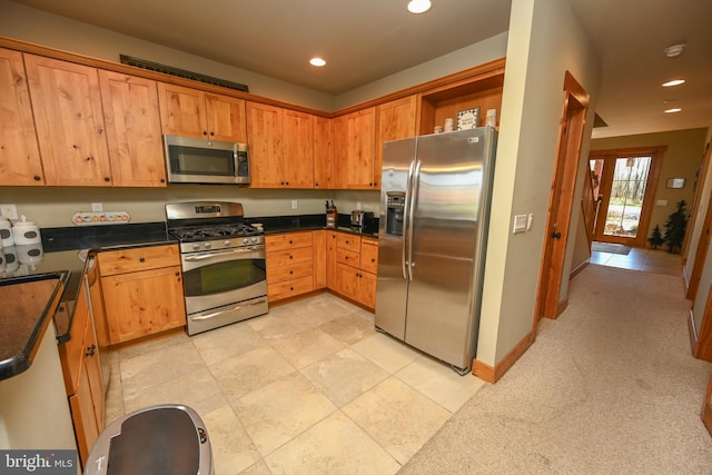 kitchen featuring light carpet and stainless steel appliances