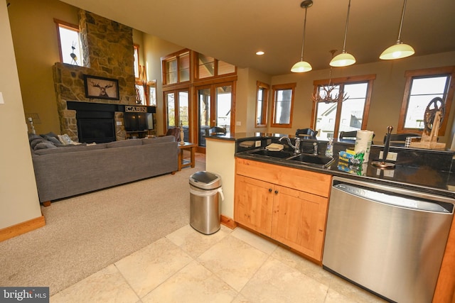 kitchen featuring sink, dishwasher, a fireplace, light carpet, and pendant lighting