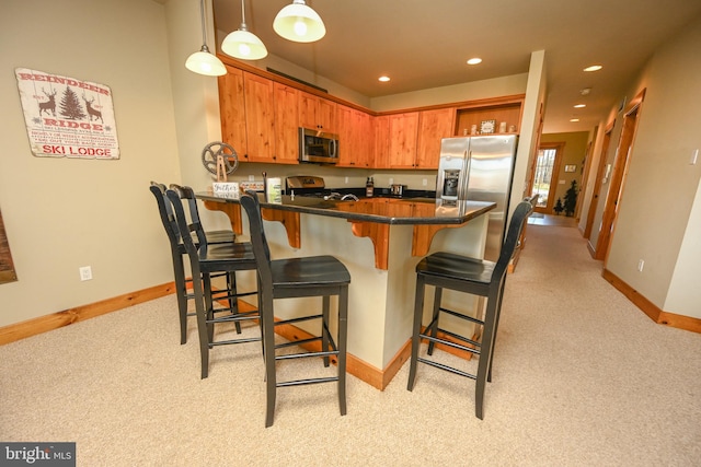 kitchen featuring light carpet, kitchen peninsula, and stainless steel appliances