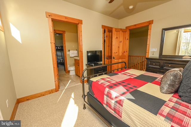 bedroom featuring light carpet, ensuite bath, and ceiling fan