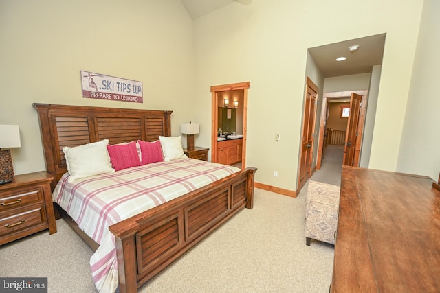 carpeted bedroom featuring a towering ceiling, a closet, and ensuite bath