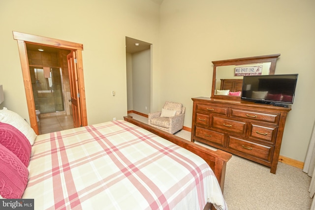 bedroom with connected bathroom and light colored carpet