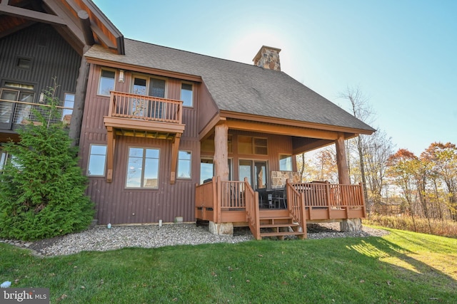 back of house featuring a yard, a balcony, and a wooden deck