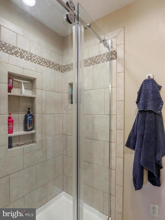 bathroom featuring a shower with shower door