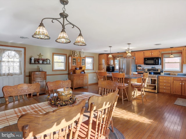 dining area with a healthy amount of sunlight and dark hardwood / wood-style flooring