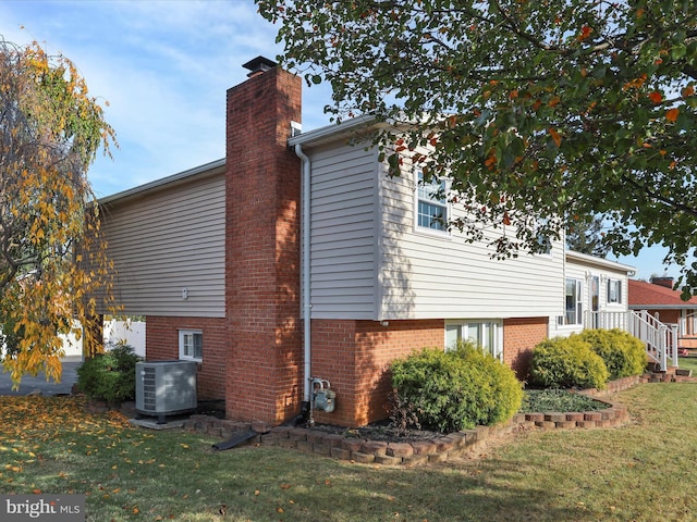 view of property exterior with cooling unit and a lawn