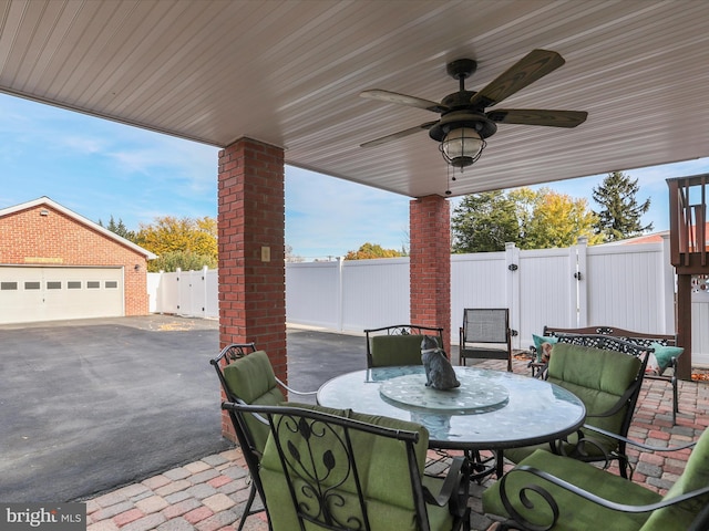 view of patio with ceiling fan and a garage