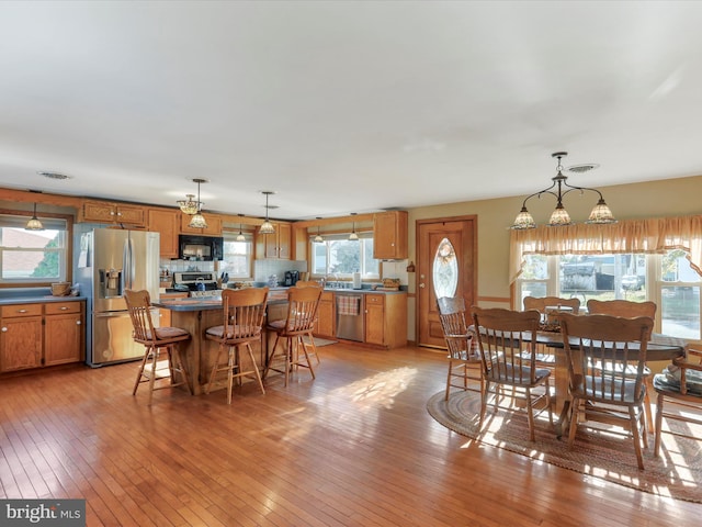 dining space with light wood-type flooring and plenty of natural light