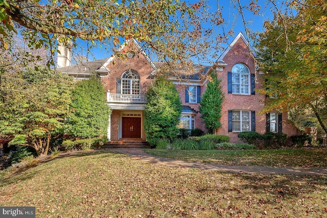 view of front of property featuring a front yard and a balcony