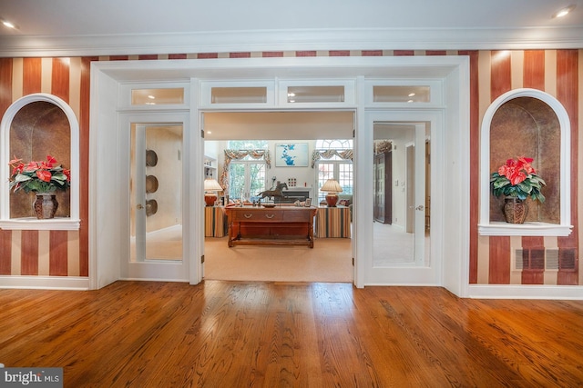 interior space with ornamental molding and wood-type flooring