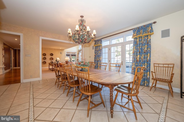 dining space with crown molding, a chandelier, and light tile patterned floors