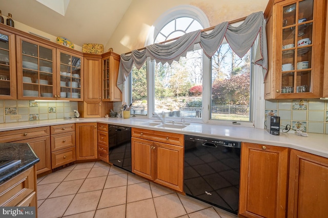 kitchen featuring decorative backsplash, dishwasher, sink, and vaulted ceiling