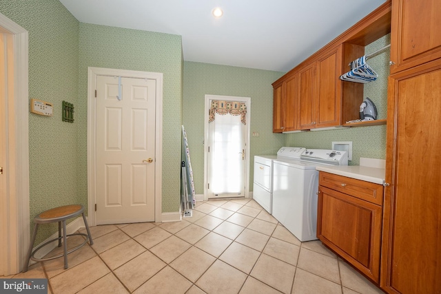 laundry area featuring independent washer and dryer, cabinets, and light tile patterned floors