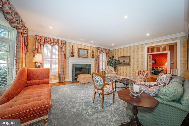 living room with crown molding, a premium fireplace, and wood-type flooring