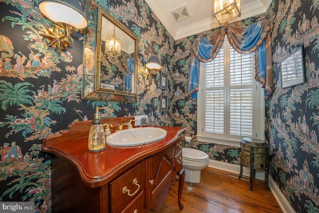 bathroom featuring vanity, toilet, ornamental molding, and hardwood / wood-style floors