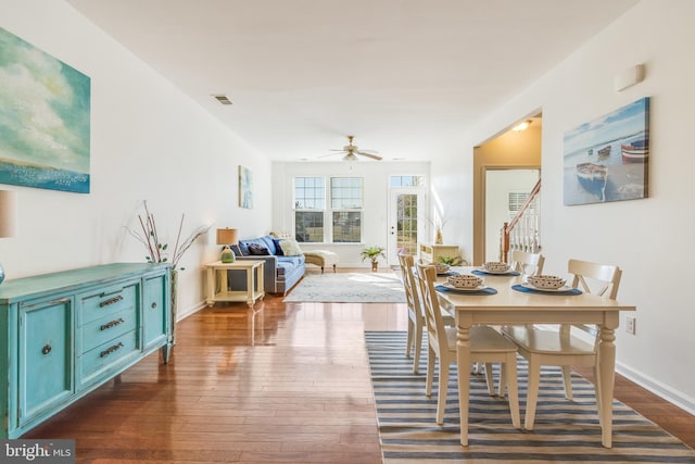 dining space with dark wood-type flooring and ceiling fan