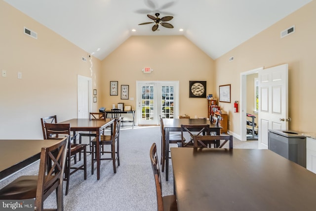 carpeted dining space featuring high vaulted ceiling and ceiling fan