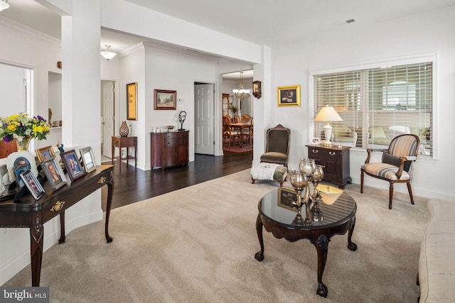 living room with ornamental molding, a notable chandelier, and dark hardwood / wood-style floors