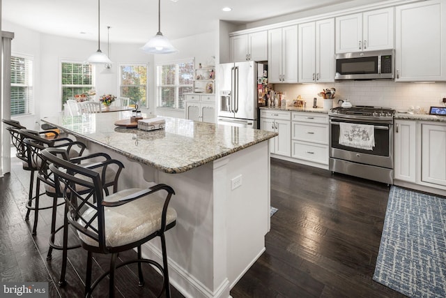 kitchen featuring a kitchen island, white cabinets, and stainless steel appliances