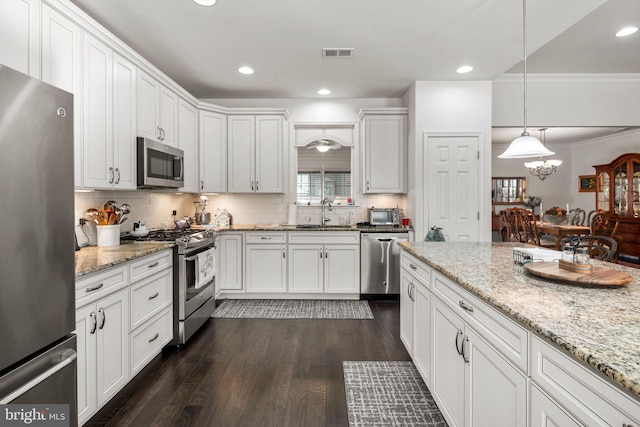 kitchen with crown molding, appliances with stainless steel finishes, dark hardwood / wood-style floors, and white cabinets