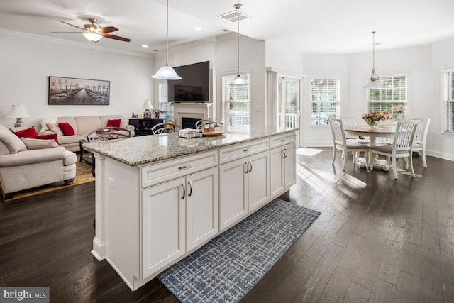 kitchen with white cabinetry, decorative light fixtures, and plenty of natural light