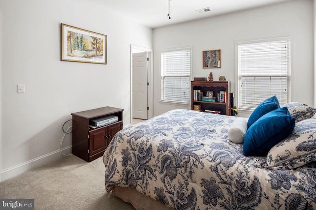 bedroom with light carpet and multiple windows