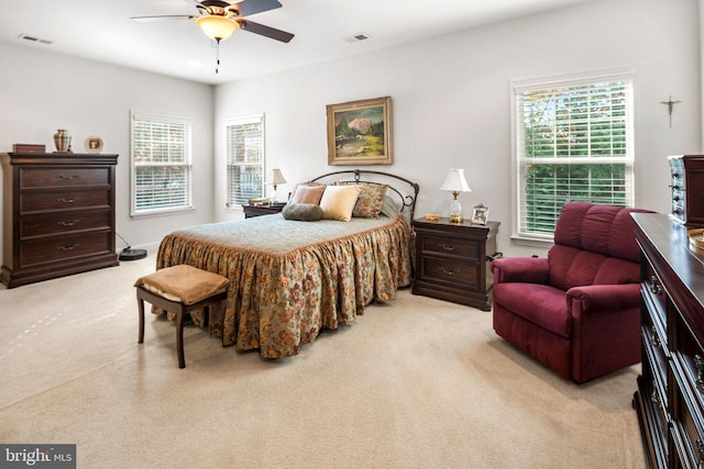 carpeted bedroom with multiple windows and ceiling fan