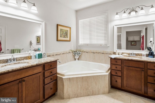 bathroom featuring vanity, a relaxing tiled tub, and tile patterned floors