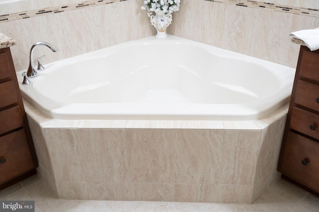 bathroom with vanity, tiled bath, and tile patterned flooring