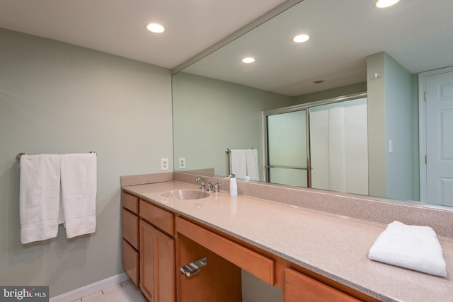 bathroom featuring vanity, a shower with shower door, and tile patterned floors