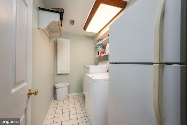 laundry area featuring light tile patterned floors and separate washer and dryer