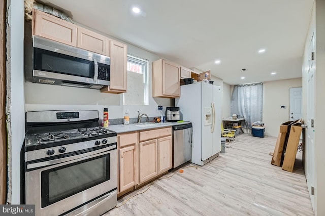 kitchen featuring light brown cabinetry, sink, light hardwood / wood-style flooring, and stainless steel appliances