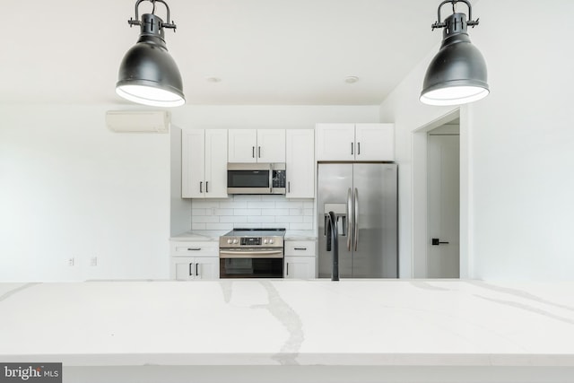 kitchen with white cabinets, light stone counters, stainless steel appliances, and tasteful backsplash