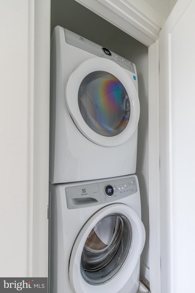 washroom featuring stacked washer / drying machine