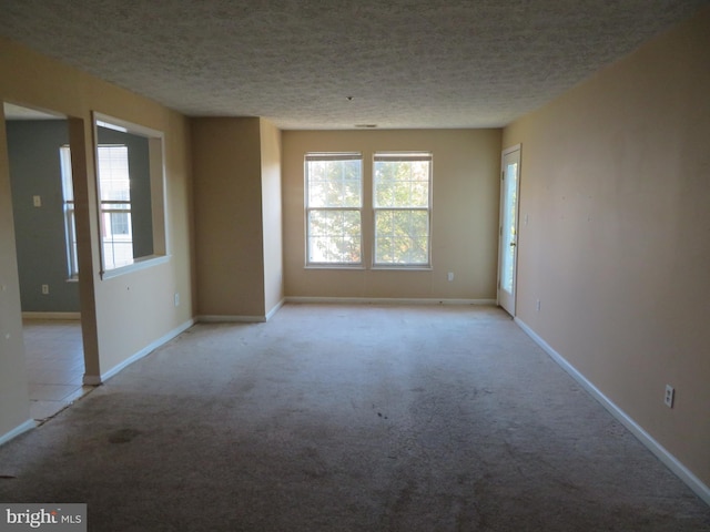 unfurnished room with a textured ceiling and light colored carpet