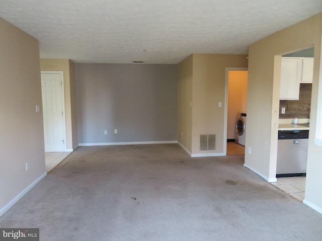 empty room featuring washer / clothes dryer and a textured ceiling