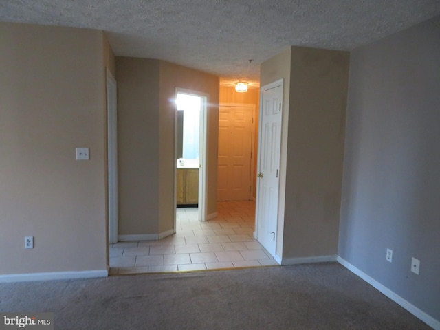 carpeted empty room with a textured ceiling