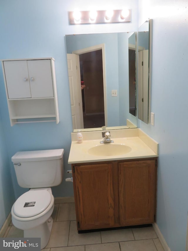 bathroom featuring toilet, vanity, and tile patterned flooring