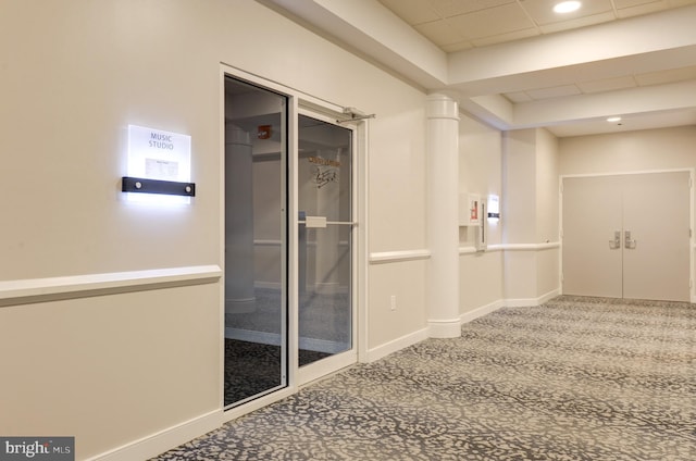 interior space with carpet flooring and a drop ceiling