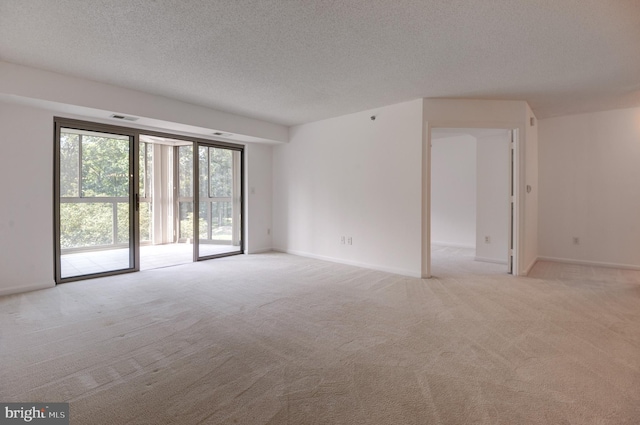 carpeted empty room featuring a textured ceiling